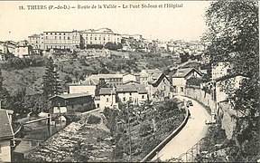 Photographie en noir et blanc. L'ancien hôpital surplombe la Vallée des Usines.