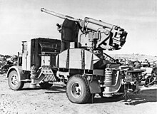 Итальянское орудие 90-53 на грузовике присоединяется к рядам заброшенных машин и оборудования Оси, сброшенных армией Роммеля.