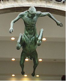 Statue représentant un homme-cheval : tête et buste d'homme, corps, membres et queue de cheval, vu de dessous.