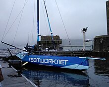 Vu de trois quarts avant, voilier bleu, amarré au ponton.