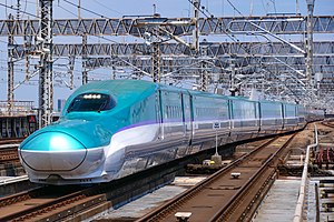 Teal and white bullet train with purple stripe
