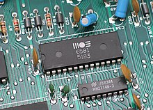 Through-hole devices mounted on the circuit board of a mid-1980s home computer. Axial-lead devices are at upper left, while blue radial-lead capacitors are at upper right. MOS6581 chtaube061229.jpg