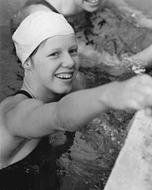 Schwarz-Weiß-Foto der 14-jährigen Barbara Hofmeister am Rand des Schwimmbeckens mit dunklem Badeanzug und heller Badekappe. Das Foto entstand anlässlich ihres ersten Meistertitels der DDR.