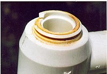 Chlorine "attack" on an acetal resin plumbing joint resulting from a fractured acetal joint in a water supply system which started at an injection molding defect in the joint and slowly grew until the part failed. The fracture surface shows iron and calcium salts that were deposited in the leaking joint from the water supply before failure and are the indirect result of the chlorine attack. Chlorine attack1.jpg