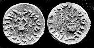 Coin of Dharaghosha, king of the Audumbaras, in the Indo-Greek style, circa 100 BCE.Obv: Standing figure, probably of Vishvamitra, Kharoshthi legend, around: Mahadevasa Dharaghoshasa/Odumbarisa "Great Lord King Dharaghosha/Prince of Audumabara", across: Viçvamitra "Vishvamitra".Rev: Trident battle-axe, tree with railing, Brahmi legend identical in content to the obverse. of