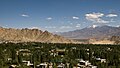 Leh in the Leh District in the state of Jammu and Kashmir in India viewing of mountains, trees and houses.