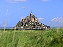 Vue générale d'un îlot construit et surmonté d'une église.