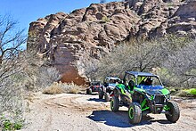 Two-seater open-wheeled off-road vehicles with a canopy.