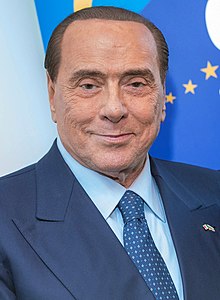 Portrait photo of a smiling Silvio Berlusconi wearing a jacket and tie