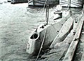 USS Holland (SS-1) in 1898. The muzzle door of the bow dynamite gun is open. Docked in New York City.