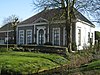 Herenhuis "Klein Raadwijk". Klein landhuis in empire stijl, met gecementeerde muren en een pannen schilddak. De voorgevel heeft een middenrisaliet, omlijst met pilasters en gedekt door een houten fronton. In het middenrisaliet bevinden zich vleugeldeuren met een versiering van pilasters, palmetkapitelen en hoofdgestel. De vensters bestaan uit achtruitsschuiframen en hoofdgestellen. Het herenhuis werd in 1840 voor de dan al bestaande boerderij gebouwd.