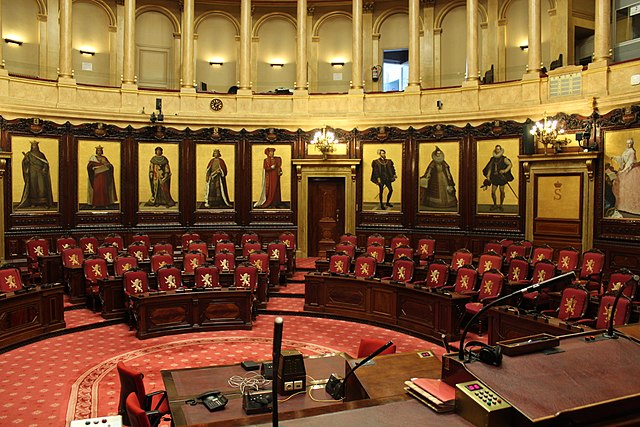  Vue de l'hémicycle du sénat belge depuis la tribune du président. Dans le fond de l'hémicycle, on voit neuf des quinze peintures historiques de Gallait qui décorent le pourtour du sénat belge. Les quinze peintures furent réalisées de 1872 à 1877. Sur la vue, on voit de gauche à droite: Philippe d'Alsace, Jean II duc de Brabant, Guillaume le Bon, Philippe le Noble, Philippe le Bon, Charles Quint, l'archiduchesse Isabelle, l'archiduc Albert, l'impératrice Marie-Thérèse.