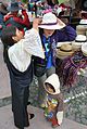 An Otavaleña in traditional dress works with a customer in the open-air market in Otavalo.