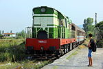 A class T669 diesel locomotive pulls a passenger train arriving at Lac station, Albania, in 2012