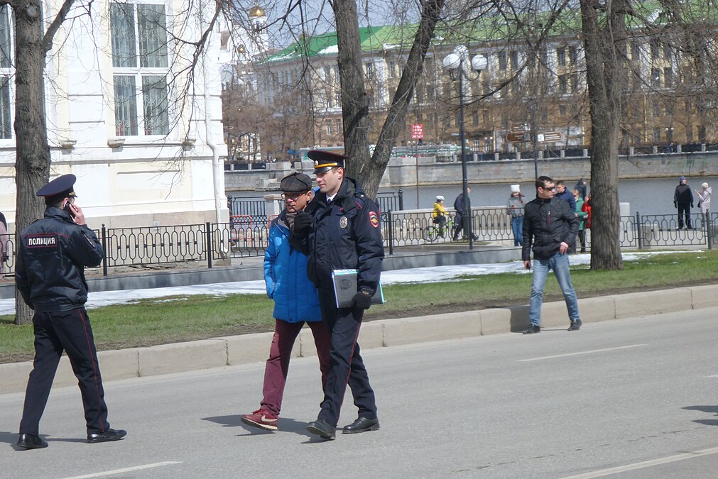 Начальник отдела Министерства общественной безопасности Свердловской области Олег Малишевский идет перед пятой колонной Первомая (рядом - офицер полиции)