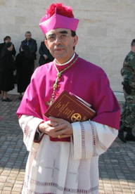 Mons. A. Castet v biskupském chórovém oděvu s biretem