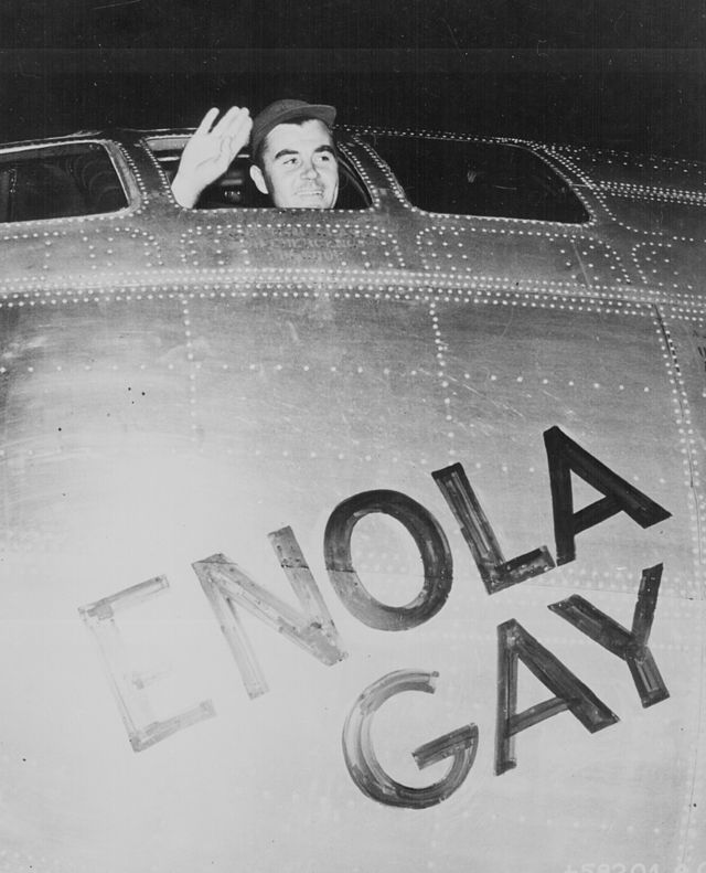 Paul Tibbets acenando da janela do cockpit do Enola Gay