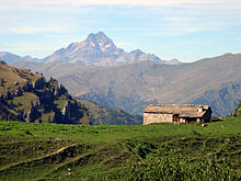 Small stone house, with mountains in background