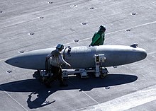 A 330-US-gallon-capacity (1,200 L) Sargent Fletcher drop tank being moved across the flight deck of an aircraft carrier