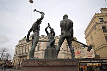 The Three Smiths Statue, situated at the intersection of Aleksanterinkatu and Mannerheimintie in Kluuvi, Helsinki, Finland Kolme seppaa - 3 smiths statue - panoramio.jpg