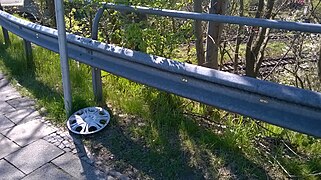 A lost plastic wheel cover next to a road