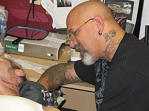 English: Tattoo artist, Shawn Conn at work in ...