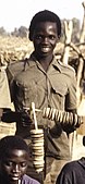 School band player holding two disc rattles (sistra), Ziguinchor, Senegal, 1973