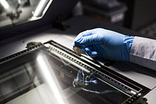 An AIATSIS pictorial technician prepares a tin type photograph for scanning. An AIATSIS pictorial technician prepares a tin type photograph for scanning.jpg