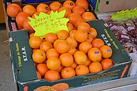 Bac d'oranges coiffé d'une étiquette jaune.