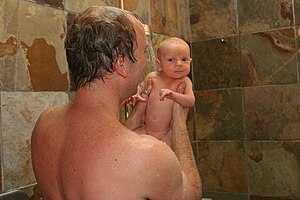 English: Father with baby in the shower.