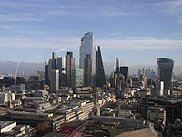 Panoráma města Londýn při pohledu z katedrály svatého Pavla, prosinec 2019. Nejvyšší zobrazená budova je 22 Bishopsgate ve výšce 278 metrů, která trumfla v roce 2019. Slavná budova „okurka“ již z tohoto úhlu není vidět. V současné době jsou v tomto klastru tři věže, které jsou vysoké přes 200 metrů, přičemž další tři byly schváleny, aby byly postaveny do 204 metrů, 249 metrů a 290 metrů do roku 2026. Vlevo je také zobrazena vznikající hvězdokupa ve Stratfordu