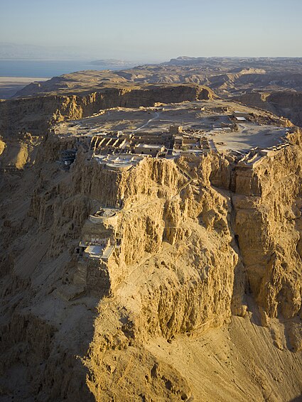 Aerial view of Masada (Hebrew מצדה), in the Judaean Desert (Hebrew: מִדְבַּר יְהוּדָה‎), with the Dead Sea and Jordan in the distance.