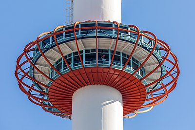 Seorang karyawan sedang membersihkan kaca jendela dek observasi di Menara Kyoto