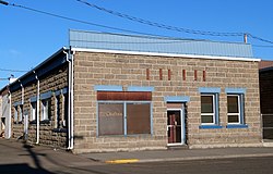 Photograph of a one-story, stone building.