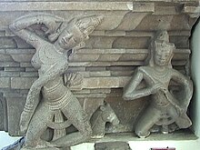 Un gandhabba (dereita) nunha escultura vietnamita do estilo Trà Kiệu (século X)