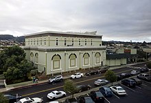 A large light green building in an urbanized area