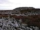 A mound of rough gritstone on a summit of stone and heather