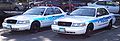 The police car on the right is a slick-top vehicle, lacking the roof-mounted lightbar seen on the traditionally equipped car on the left.