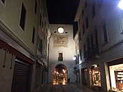 Ein Durchgang durch einen Turm mit einem Markuslöwen im Zentrum von Spilimbergo bei Nacht.