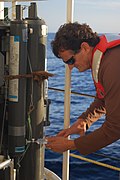 A scientist collects water from a Niskin bottles directly into a syringe type filtration container on NOAA Ship PISCES.