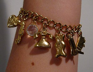 English: A gold charm bracelet worn on the arm...