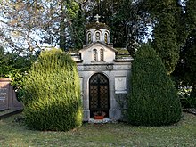 Mausoleum von Karadjordjevic in Genf. Bau im Stil einer orthodoxen Kirche mit Kuppel zwischen zwei Eibenbüschen. Die Front ist mit Kreuzen, Weinranken und einem Wappen verziert.