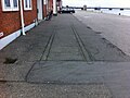 For enden af kajen ser man tydeligt spor 2 lige under asfalten, og der er asfalteret efter at en stopbom er fjernet