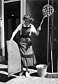 Huisvrouw met mattenklopper (omstreeks 1955)