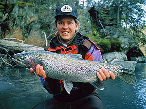 English: Man holding a rainbow trout (Oncorhyn...