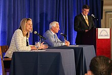 Simmons sits at a table next to Valentine for the Chamber of Commerce debate.