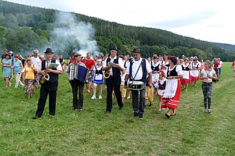 Průvod svatebčanů směřující k hospodě