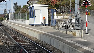 Concrete platform with white stripe next to single railway track