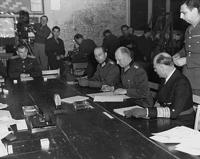 Fra venstre til højre: Major Wilhelm Oxenius, general Jodls adjudant, general Alfred Jodl, lederen af den tyske delegation generaladmiral Hans-Georg von Friedeburg, generalmajor Kenneth W. D. Strong. Taget i Reims den 7. maj 1945.