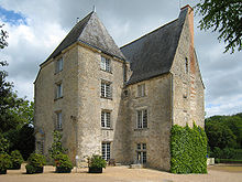 Photographie couleur d'une bâtiment en pierre sur quatre niveaux dont le toit est en ardoise